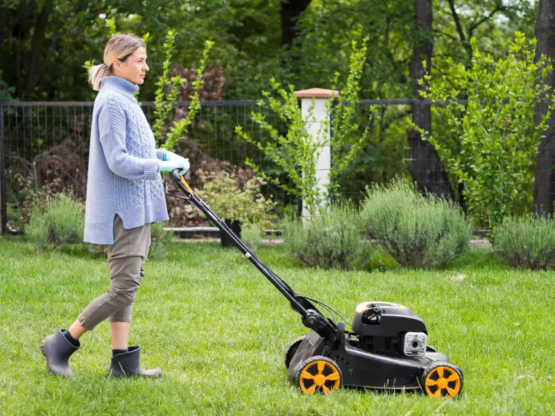 long shot woman mowing yard (1)